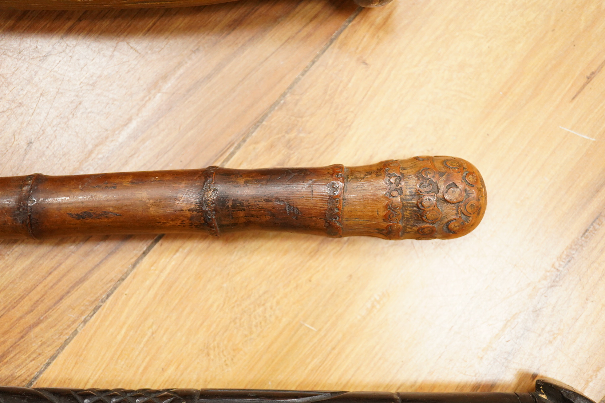 Five walking sticks including horn and a silver topped walking sticks and a carved topped walking stick with concealed chamber containing a metal tube - 93cm long. (5).